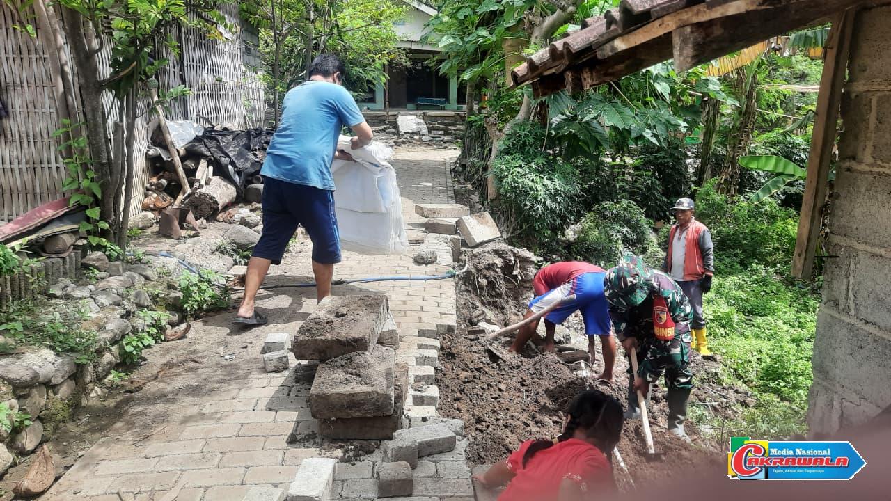 Babinsa dan warga Desa Leprak bergotong-royong membangun tembok penahan tanah untuk cegah longsor di Bondowoso.