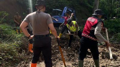 Personel Polres Batu membersihkan material longsor di Ngantang hingga akses Malang-Blitar kembali normal.