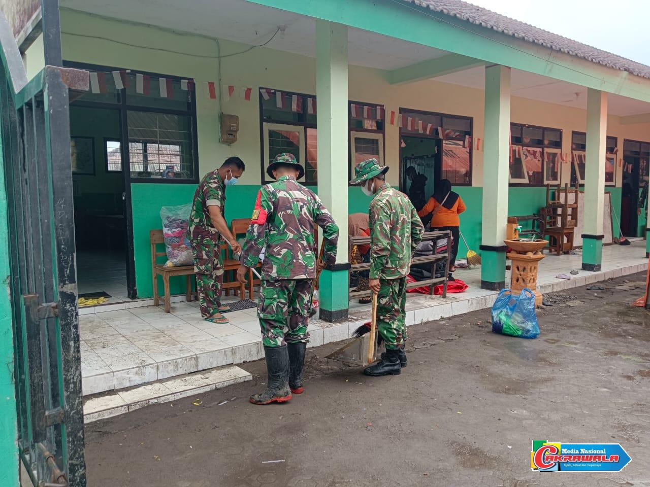 Personel TNI dan guru membersihkan ruang kelas di SDN Supiturang untuk pemulihan pascaerupsi Semeru.