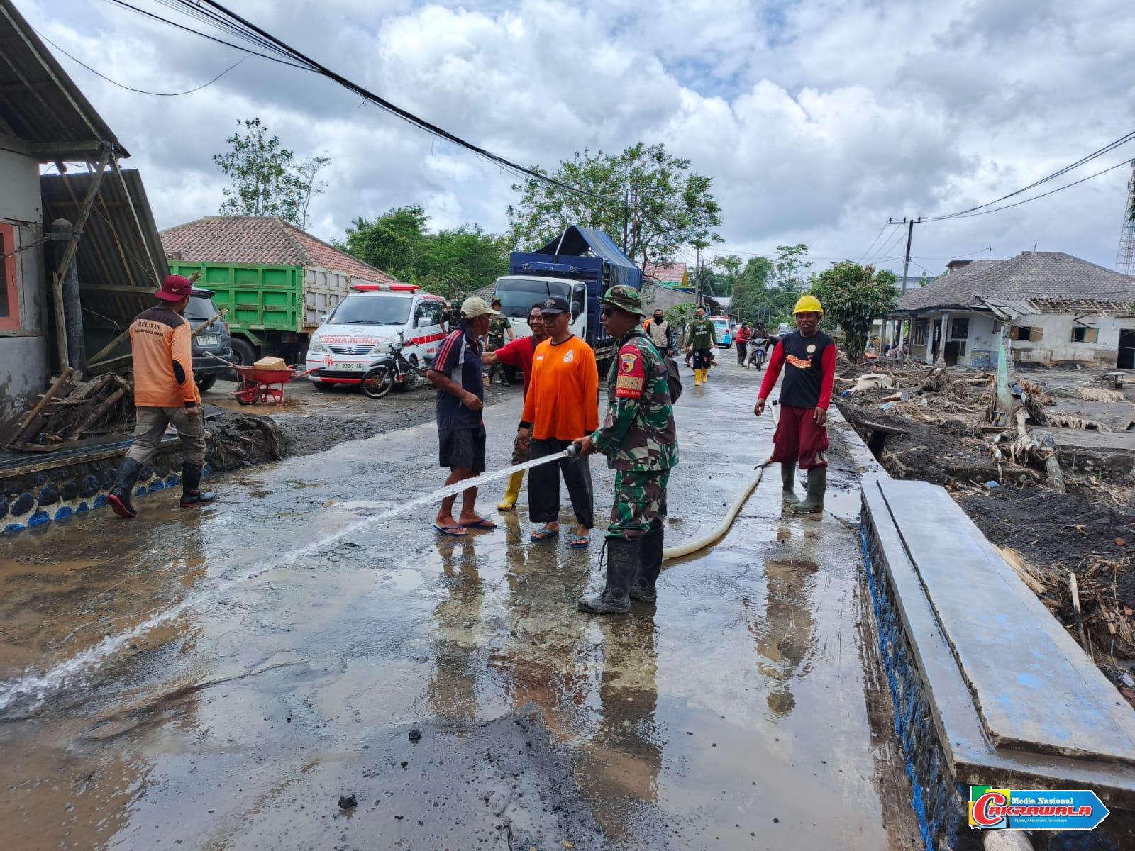 Personel TNI dan relawan melakukan Pemulihan bencana Lumajang dengan membersihkan jalan utama.