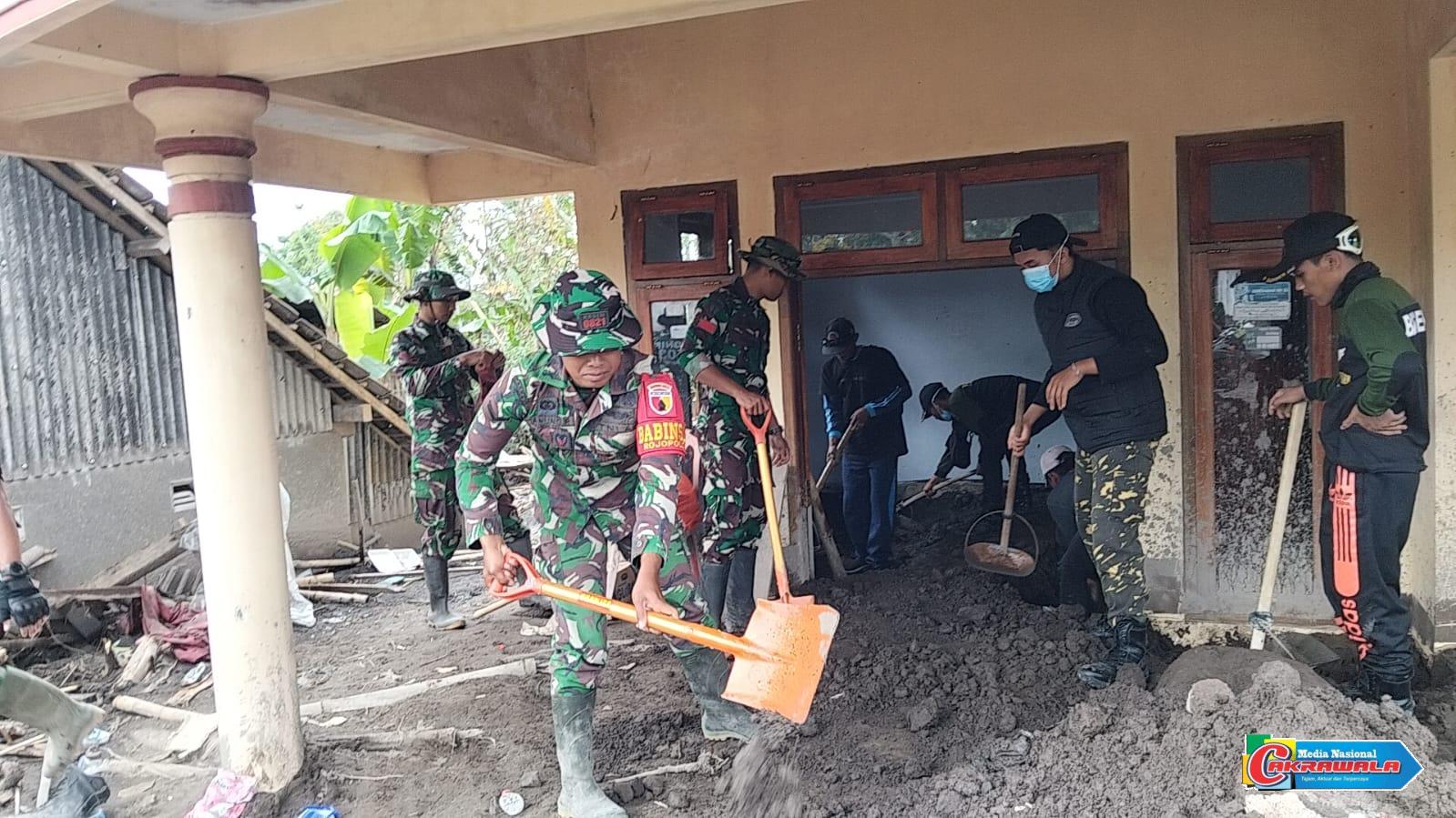 Personel Kodim 0821 Lumajang membersihkan material pasir di rumah warga terdampak erupsi Semeru di Desa Supiturang.