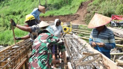 Babinsa Gading Sari Bersama Warga Kerjakan Pengecoran Balok Tarik Jembatan